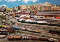 Salfred-West Bahnhof aus der Vogelperspektive mit der Hauptbahn nach Kellerstadt im Mittelgrund und der oestlichen Ausfahrt von Salfred-Süd im Vordergrund